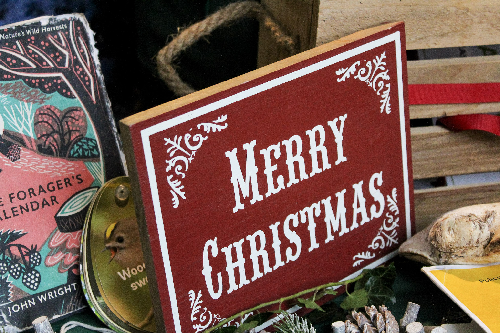 A wooden sign with Merry Christmas written on it as part of a festive display