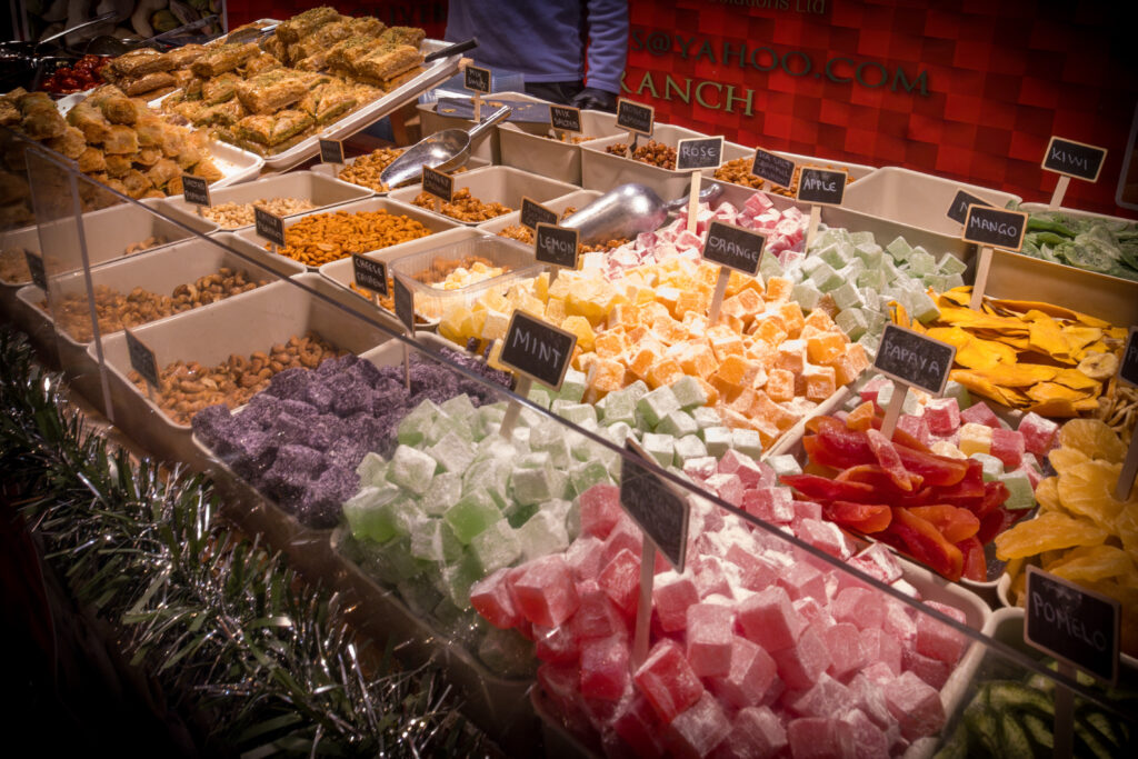 A close up lots of different types of colourful sweets on a market stall